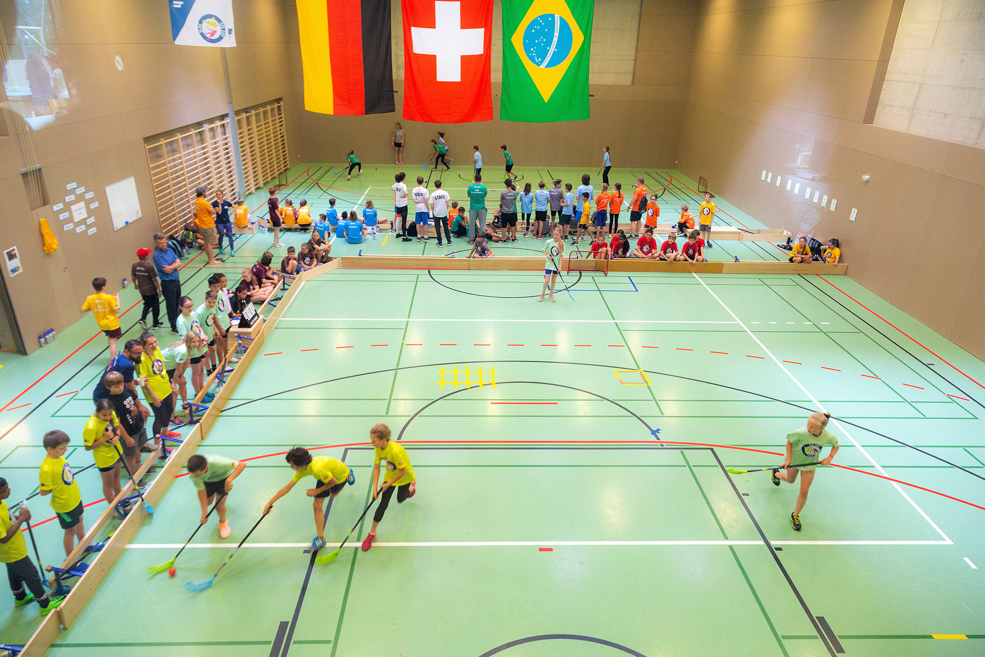 Il torneo di floorball durante la SIS Cup si tiene in una palestra grande della scuola. Sul soffitto sono appese le bandiere di Germania, Brasile e Svizzera.