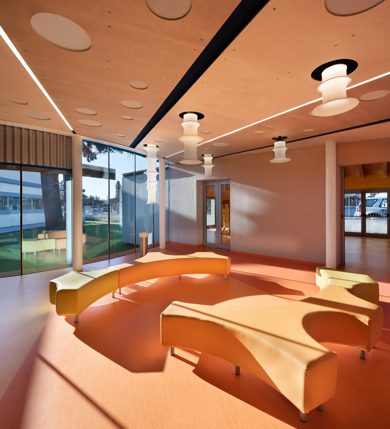 A light-flooded space for socialising at school. Two organically shaped benches invite students to linger and communicate with each other. 