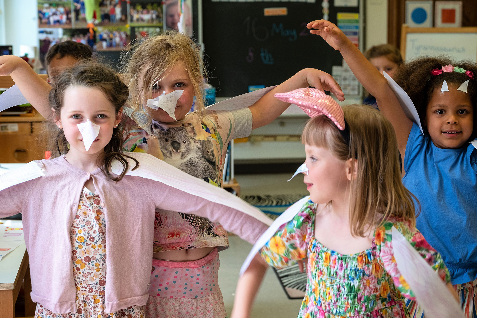 Four girls dressed up and happy in class.