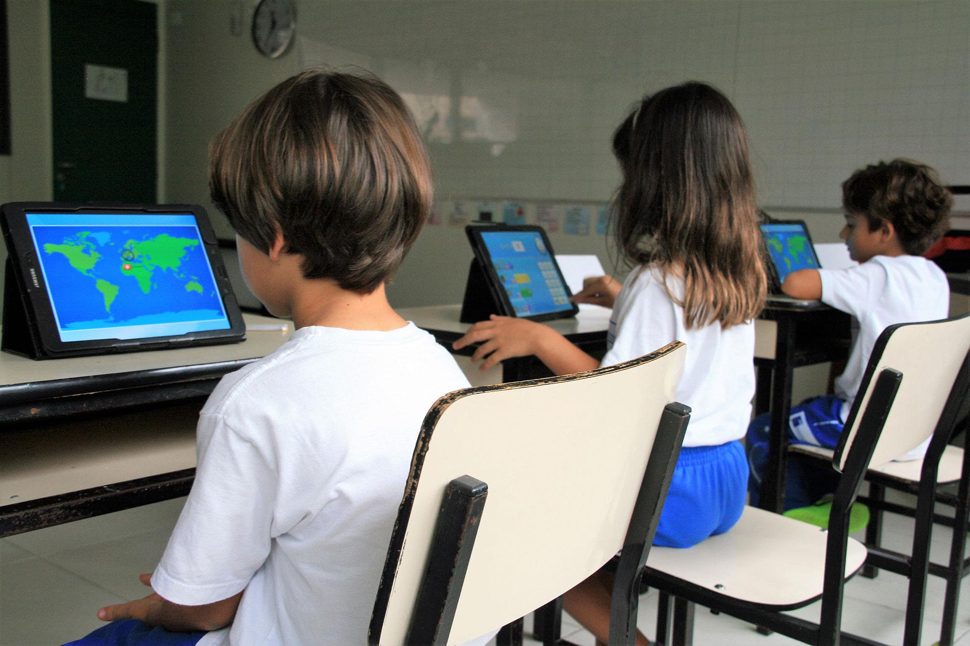 Una bambina e un bambino davanti al computer si concentrano per risolvere alcuni problemi di matematica durante il SIS Maths Day.